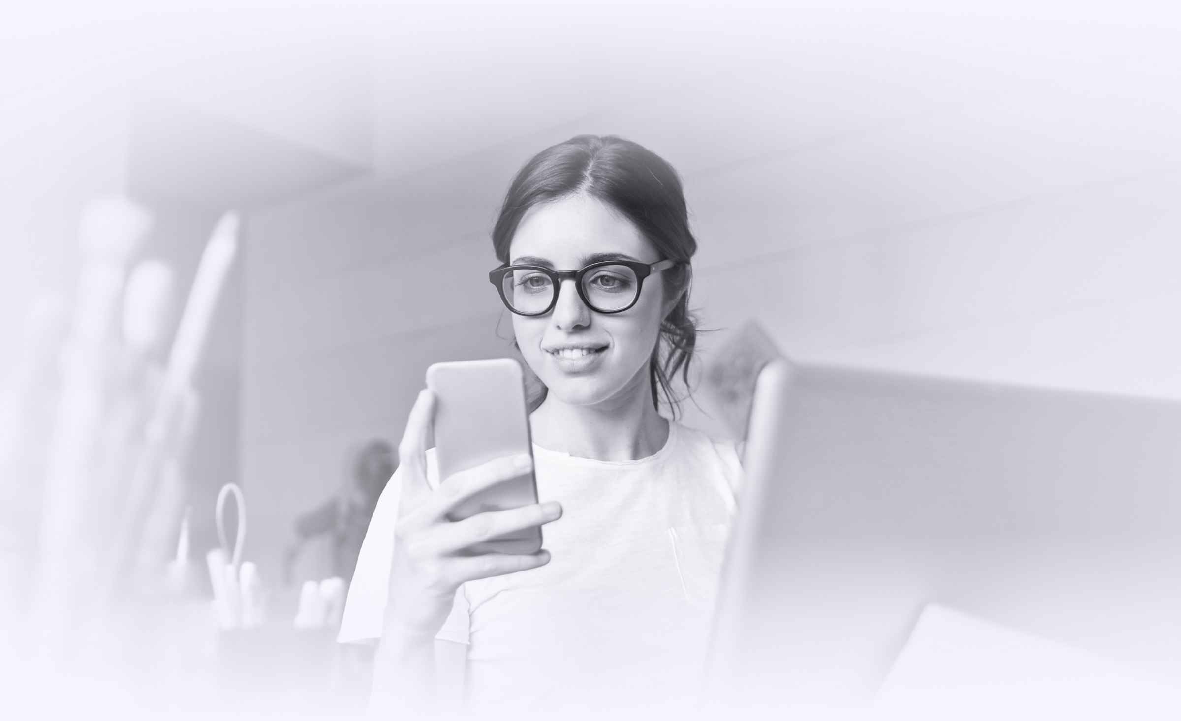 Woman with glasses giving thumbs up, smiling